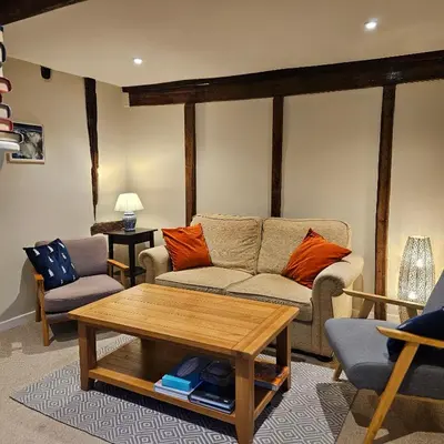 a living room with a couch and a coffee table at The Old Flint Bank Cottage in Harleston