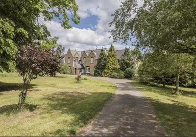a country house with a road in front of it at Cockayne Hatley Hall in Cockayne Hatley