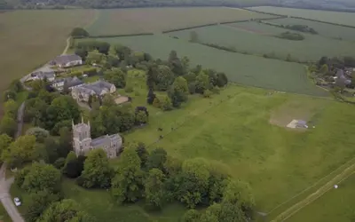 an aerial view of an old castle on a green field at Cockayne Hatley Hall in Cockayne Hatley