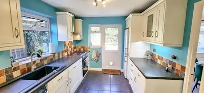 a kitchen with white cabinets and a sink at Chelmsford Comfort Retreat Spacious 4 Bedroom Sleeps 7 Free Parking in Widford