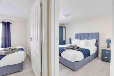 a bedroom with two beds and a window at Elm Cottage Ipswich in Ipswich