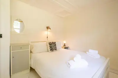 a bedroom with a white bed with towels on it at 6 Uplands in Thorpeness