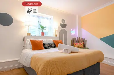 a bedroom with a bed with a laptop on it at Quiet Premium Stansted Apartment in Central Location with WiFi and Desk in Stansted Mountfitchet