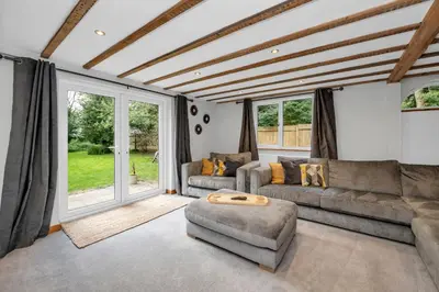 a living room with two couches and a table at Stunning 2 Lodge Cottage retreat in Little Saxham