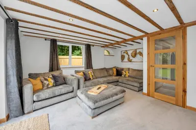 a living room with two couches and a table at Stunning 2 Lodge Cottage retreat in Little Saxham