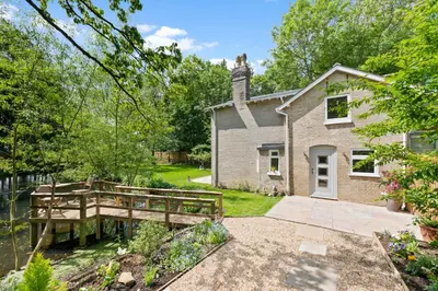 a house with a wooden bridge in front of it at Stunning 2 Lodge Cottage retreat in Little Saxham