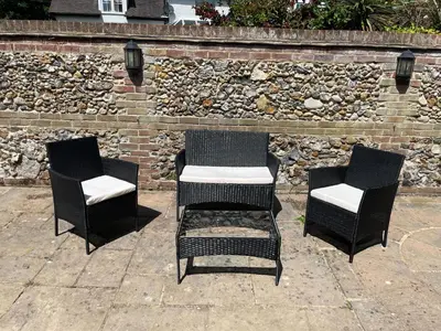 three black chairs sitting next to a brick wall at Kings Barn - English Countryside Retreat in Lindsell