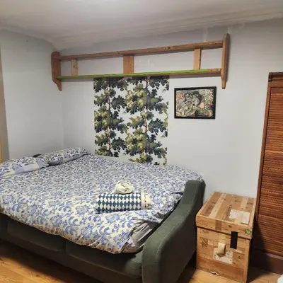 a bedroom with a bed with a blue comforter at Great Central self-contained flat in Cambridge