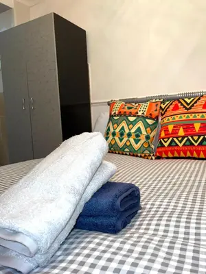 a bedroom with a bed with towels on it at Penn Gardens Spacious king size room- 3 in Friern Barnet