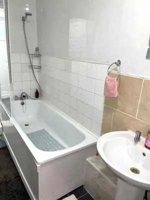 a bathroom with a bath tub and a sink at Penn Gardens Spacious king size room- 3 in Friern Barnet