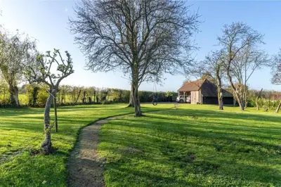 a path in a field with trees and a house at Old Cottage - English Countryside Retreat in Lindsell