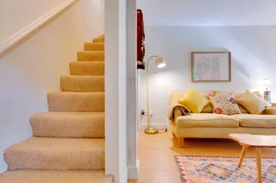 a living room with a staircase and a couch at Pass the Keys Charming Cottage in City Centre with Free parking in Cambridge