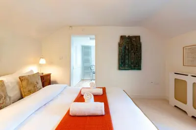 a bedroom with a large bed with a towel on it at Pass the Keys Charming Cottage in City Centre with Free parking in Cambridge