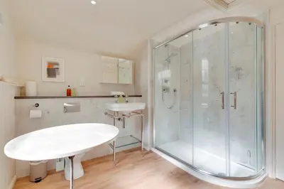 a bathroom with a glass shower and a sink at Pass the Keys Charming Cottage in City Centre with Free parking in Cambridge