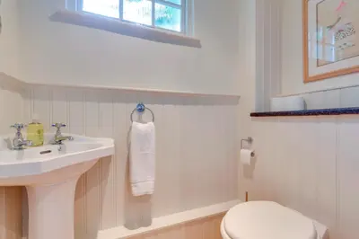 a white bathroom with a sink and a toilet at Pass the Keys Charming Cottage in City Centre with Free parking in Cambridge
