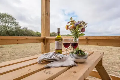 a table with a bottle of wine and a glass at River Retreat, Aldeburgh in Aldeburgh