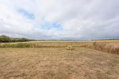 a picnic table in the middle of a field at River Retreat, Aldeburgh in Aldeburgh