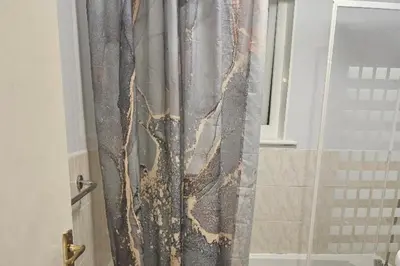 a shower curtain in a bathroom with a glass door at 1 Bed House Sleeps 2 -Free Parking -Tv in Romford