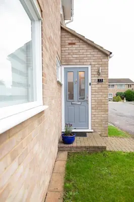 a brick house with a blue door and a window at Lovely 3 Bedroom House in Chelmsford in Chelmsford