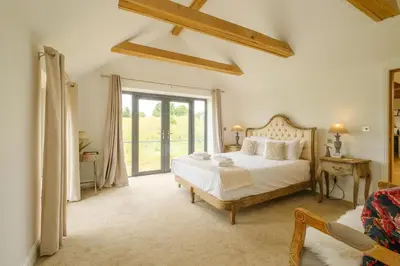 a bedroom with a bed and a large window at Sandown in Snape