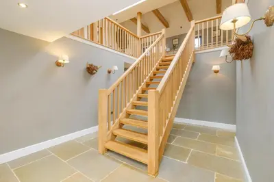 a wooden staircase in a home with white walls at Sandown in Snape