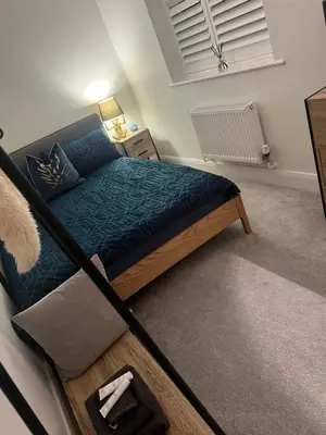 a bedroom with a bed with a blue comforter at Cosy room in Great Bromley