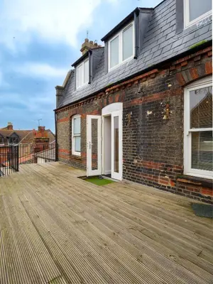 a brick house with a large wooden deck at Contractor's Haven 4BED 2BATH House in Ipswich with FREE Parking in Ipswich