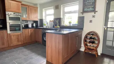 a kitchen with wooden cabinets and a counter top at Single Room Near Basildon City Centre in Basildon