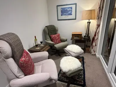 a living room with two chairs and a table at Tresco - Aldeburgh's hidden gem in Aldeburgh