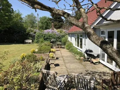 a house with a yard with chairs and a table at Tresco - Aldeburgh's hidden gem in Aldeburgh