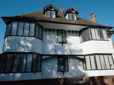 a white house with black windows on the side of it at Top Deck at The Cabin in Fornham Saint Martin