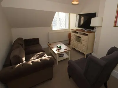a living room with a couch and a tv at Top Deck at The Cabin in Fornham Saint Martin