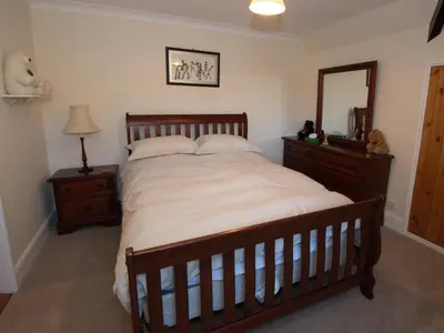 a bedroom with a large bed and a mirror at Top Deck at The Cabin in Fornham Saint Martin