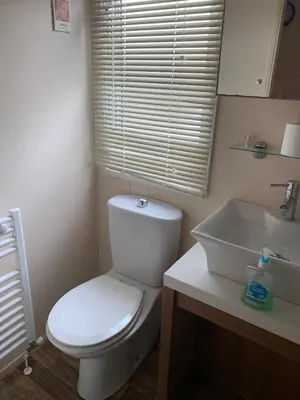 a bathroom with a white toilet and a sink at Lakeside Lodge Valencia 2 bedroom in Weeley