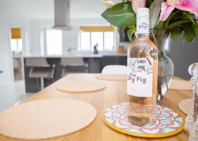 a bottle of wine sitting on a table with a vase at 4x Bed Luxurious Home With a View in Downham Market