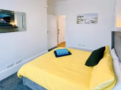 a bedroom with a yellow bed with a blue bag on it at Sea Leigh in Leigh-on-Sea