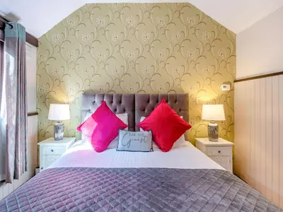a bedroom with a bed with red and pink pillows at Robin - Uk48171 in Colchester