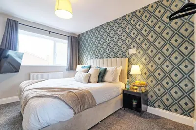 a bedroom with a large bed and a wall at Modern 5-Bed Property, Ideal for Extended Business & Contractor Stays in Colchester