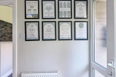 a group of framed signs on a wall above a door at Modern 5-Bed Property, Ideal for Extended Business & Contractor Stays in Colchester