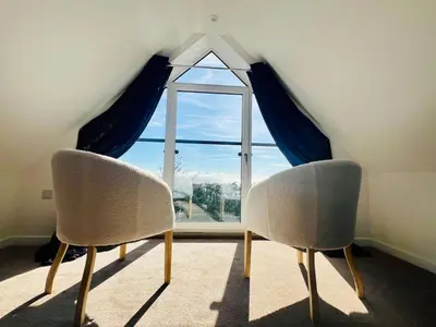 two chairs sitting in front of a window at Unique Apartment with Stunning Views 2B in Felixstowe