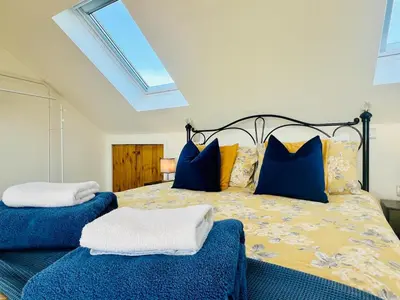 a bedroom with a bed with blue and yellow pillows at Unique Apartment with Stunning Views 2B in Felixstowe