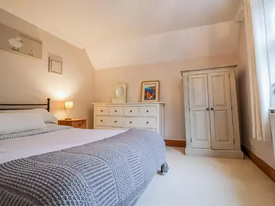 a bedroom with a bed and a dresser and a window at Brook Lodge in Ipswich
