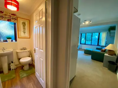 a bathroom with a toilet and a sink and a couch at The Annex in Tostock
