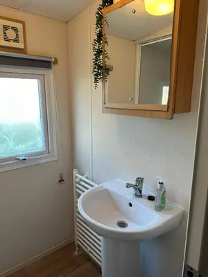a bathroom with a sink and a mirror and a window at Beatrice homes in Parkeston