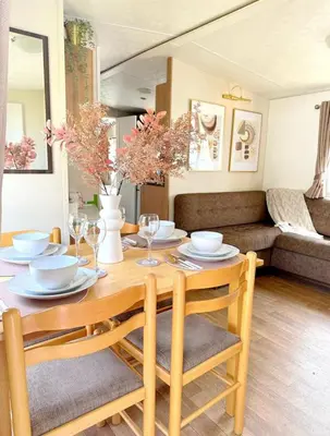 a wooden table with chairs and a dining room at Beatrice homes in Parkeston