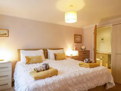 a bedroom with a large white bed with two pillows at Oakleaves in Colchester