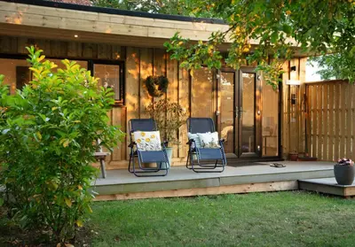 two chairs sitting on a porch in front of a house at Copper Beech Lodge with Hot Tub, Games Room, Fire Pit in Toppesfield