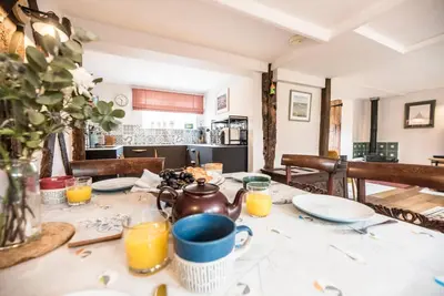 a table with a tea kettle and plates on it at Blythburgh Cottage, Yoxford in Yoxford