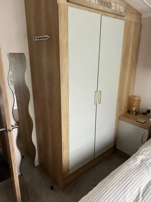 a bedroom with a bed and a closet with a door at Mimosa lodge in Little Clacton