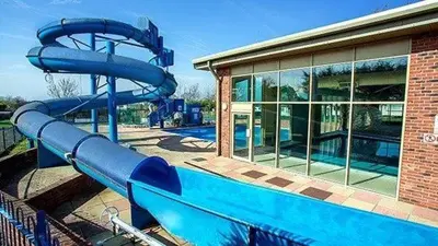 a blue water slide in front of a building at Mimosa lodge in Little Clacton